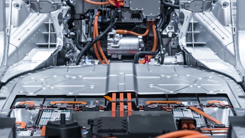 Inside the chassis of an electric vehicle with no interior to show the wire harness design for the EV batteries and electric motor  